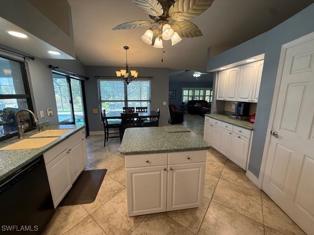 1200 Elaine Ave N, Lehigh Acres, FL 33971 - kitchen with black dishwasher, a sink, ceiling fan, vaulted ceiling, and white cabinets