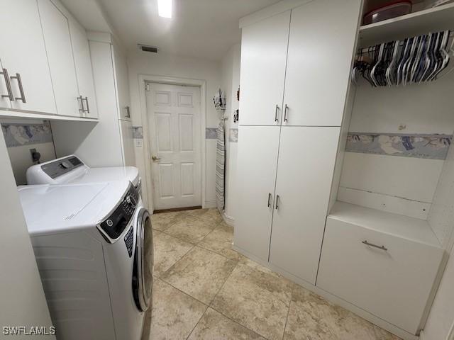 1200 Elaine Ave N, Lehigh Acres, FL 33971 - clothes washing area featuring cabinet space, washer and dryer, and light tile patterned floors