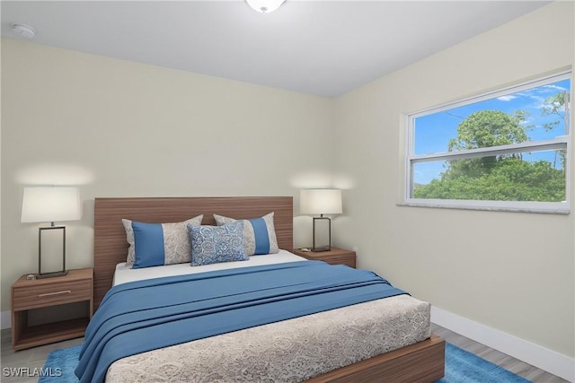 876 Apartment St E, Lehigh Acres, FL 33974 - bedroom with baseboards and wood finished floors
