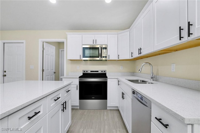 876 Apartment St E, Lehigh Acres, FL 33974 - kitchen with stainless steel appliances, a sink, white cabinets, light stone counters, and recessed lighting