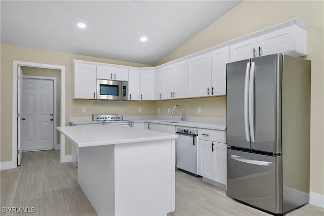 876 Apartment St E, Lehigh Acres, FL 33974 - kitchen featuring stainless steel appliances, white cabinetry, light countertops, a kitchen island, and vaulted ceiling