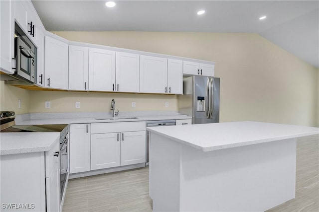 876 Apartment St E, Lehigh Acres, FL 33974 - kitchen featuring lofted ceiling, stainless steel appliances, a sink, light countertops, and white cabinets