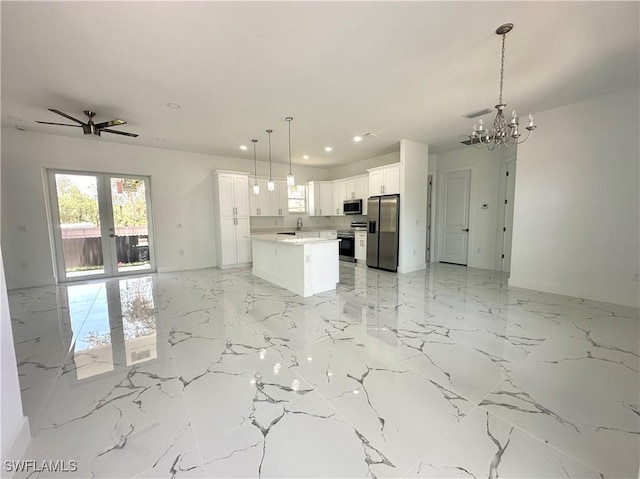 kitchen featuring appliances with stainless steel finishes, open floor plan, recessed lighting, a chandelier, and light marble finish floors