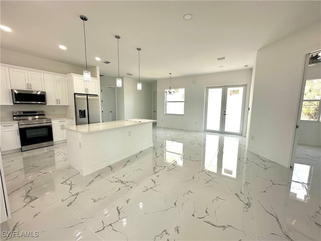 kitchen featuring appliances with stainless steel finishes, light marble finish floors, healthy amount of natural light, and recessed lighting
