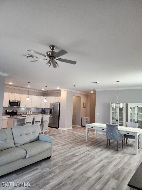 16006 Mistflower Dr, Alva, FL 33920 - living area with ornamental molding, light wood-style floors, ceiling fan, and recessed lighting