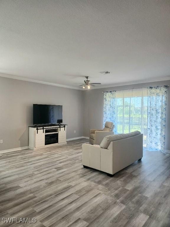 16006 Mistflower Dr, Alva, FL 33920 - living room featuring ornamental molding, wood finished floors, ceiling fan, and a fireplace