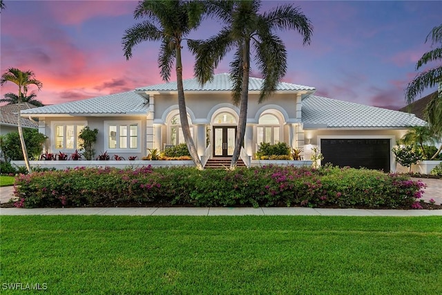 287 Meadowlark Ct, Marco Island, FL 34145 - mediterranean / spanish house featuring french doors, a front lawn, an attached garage, stucco siding, and a tile roof