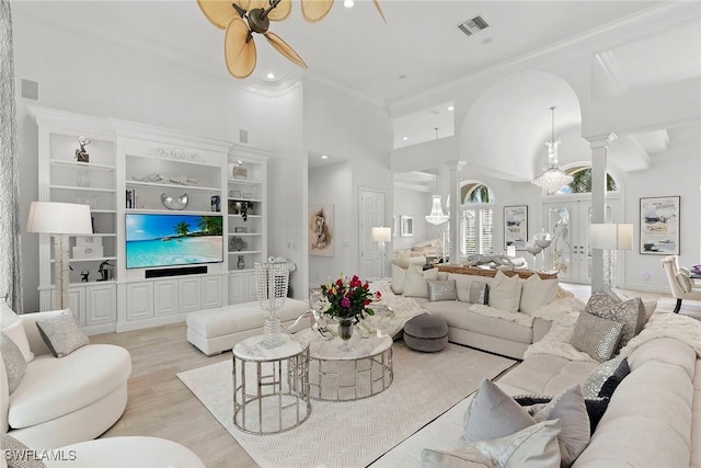 287 Meadowlark Ct, Marco Island, FL 34145 - living room featuring decorative columns, ceiling fan, light wood-style floors, built in shelves, and crown molding