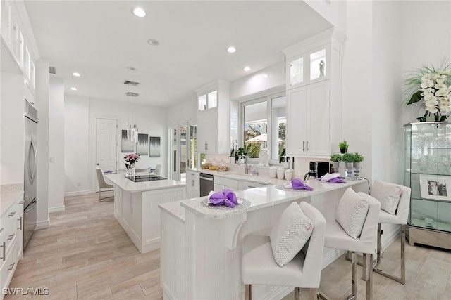 287 Meadowlark Ct, Marco Island, FL 34145 - kitchen featuring appliances with stainless steel finishes, a kitchen island, light wood-style flooring, a peninsula, and recessed lighting