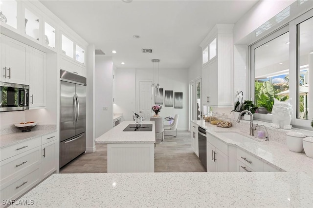 287 Meadowlark Ct, Marco Island, FL 34145 - kitchen featuring appliances with stainless steel finishes, a sink, light wood-type flooring, a kitchen island, and white cabinetry