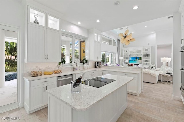 287 Meadowlark Ct, Marco Island, FL 34145 - kitchen featuring stainless steel appliances, a peninsula, a kitchen island, open floor plan, and healthy amount of natural light