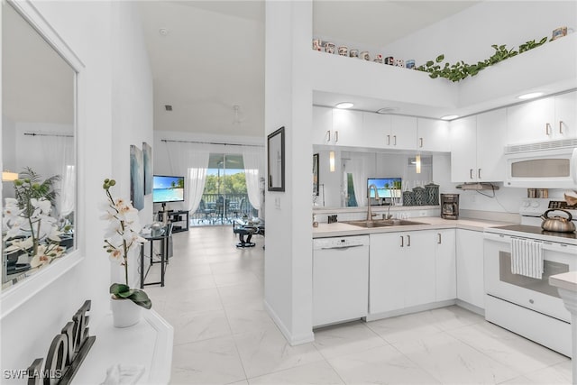 154 Newport Dr Unit 1307, Naples, FL 34114 - kitchen with white appliances, a high ceiling, a sink, light marble finish floors, and light countertops