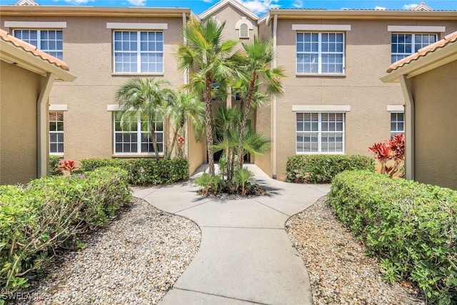 20101 Seagrove St Unit 702, Estero, FL 33928 - view of exterior entry with stucco siding and a tiled roof