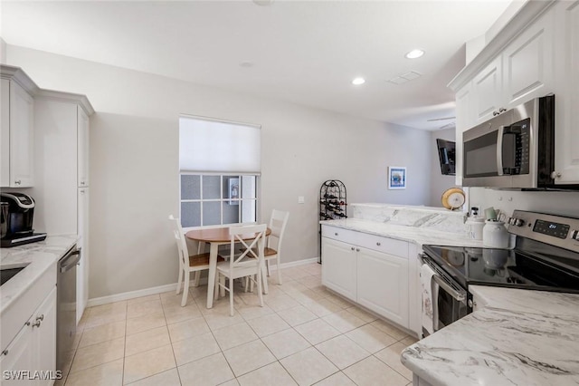 20101 Seagrove St Unit 702, Estero, FL 33928 - kitchen with appliances with stainless steel finishes, recessed lighting, light tile patterned floors, a peninsula, and light stone counters