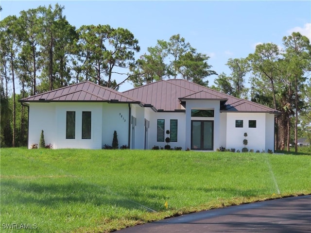 3813 16th Ave NE, Naples, FL 34120 - view of front of house with a standing seam roof, stucco siding, metal roof, and a front yard