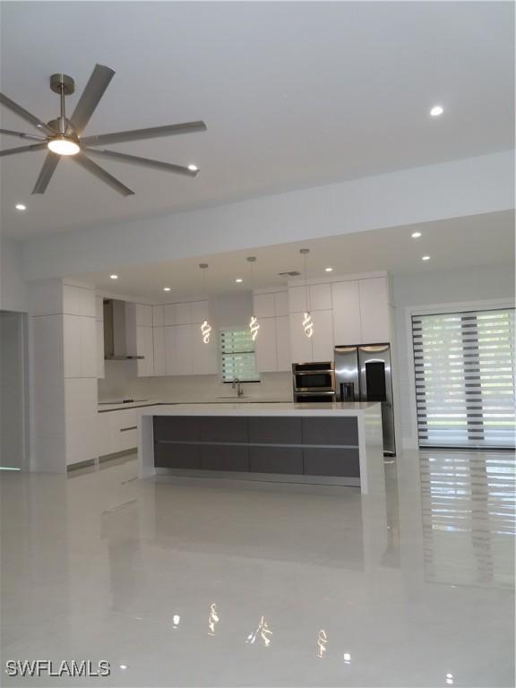 3813 16th Ave NE, Naples, FL 34120 - kitchen featuring modern cabinets, wall chimney range hood, white cabinets, a sink, and recessed lighting