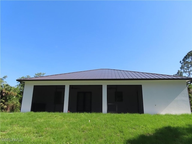 3813 16th Ave NE, Naples, FL 34120 - back of property with stucco siding, a lawn, metal roof, and a standing seam roof