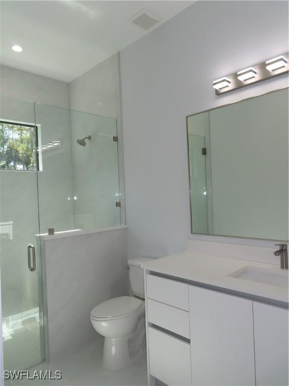 3813 16th Ave NE, Naples, FL 34120 - full bathroom with a shower stall, vanity, and toilet