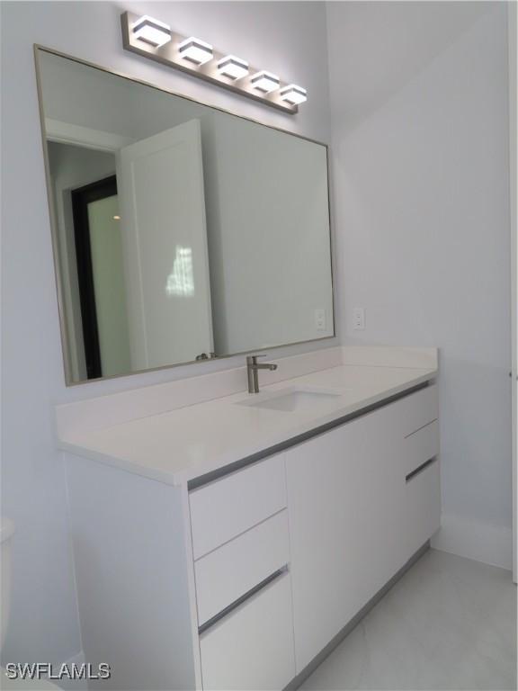 3813 16th Ave NE, Naples, FL 34120 - bathroom with vanity and baseboards