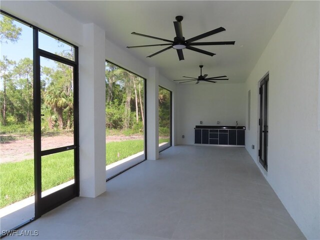 3813 16th Ave NE, Naples, FL 34120 - unfurnished sunroom with plenty of natural light and a ceiling fan