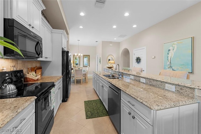 10450 Materita Dr, Fort Myers, FL 33913 - kitchen with black appliances, a sink, white cabinetry, recessed lighting, and a chandelier