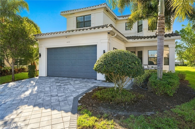 4172 Crescent Ct, Naples, FL 34119 - mediterranean / spanish-style house with stucco siding, decorative driveway, an attached garage, and a tile roof