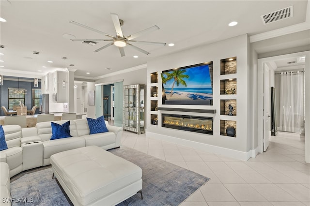 4172 Crescent Ct, Naples, FL 34119 - living room with ornamental molding, a ceiling fan, recessed lighting, a glass covered fireplace, and light tile patterned floors