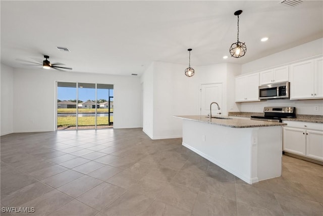 3663 Wild Sage Way, Alva, FL 33920 - kitchen featuring appliances with stainless steel finishes, a sink, open floor plan, a kitchen island with sink, and dark stone counters