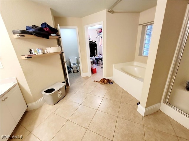 506 Desoto Ave, Lehigh Acres, FL 33972 - full bath featuring toilet, a garden tub, a shower stall, vanity, and tile patterned floors