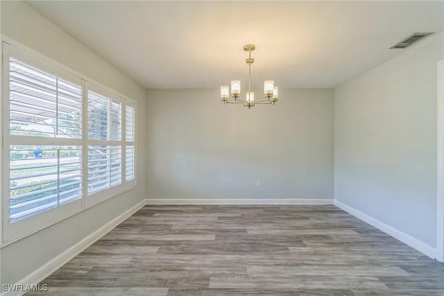 4330 S Canal Cir, North Fort Myers, FL 33903 - spare room with a chandelier, wood finished floors, and baseboards