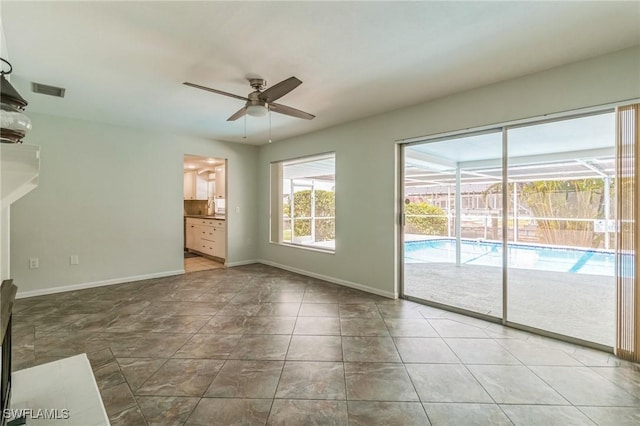 4330 S Canal Cir, North Fort Myers, FL 33903 - unfurnished living room with a ceiling fan, a sunroom, baseboards, and tile patterned flooring
