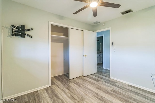 4330 S Canal Cir, North Fort Myers, FL 33903 - unfurnished bedroom with light wood-style flooring, baseboards, a closet, and a ceiling fan