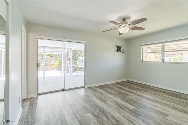 4330 S Canal Cir, North Fort Myers, FL 33903 - empty room with wood finished floors, a ceiling fan, baseboards, and plenty of natural light