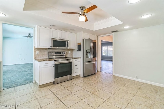 4330 S Canal Cir, North Fort Myers, FL 33903 - kitchen featuring stainless steel appliances, a tray ceiling, ceiling fan, white cabinetry, and recessed lighting