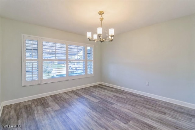 4330 S Canal Cir, North Fort Myers, FL 33903 - spare room featuring a chandelier, wood finished floors, and baseboards