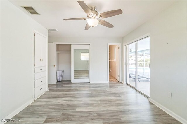 4330 S Canal Cir, North Fort Myers, FL 33903 - unfurnished bedroom featuring access to outside, baseboards, light wood-style floors, and ceiling fan