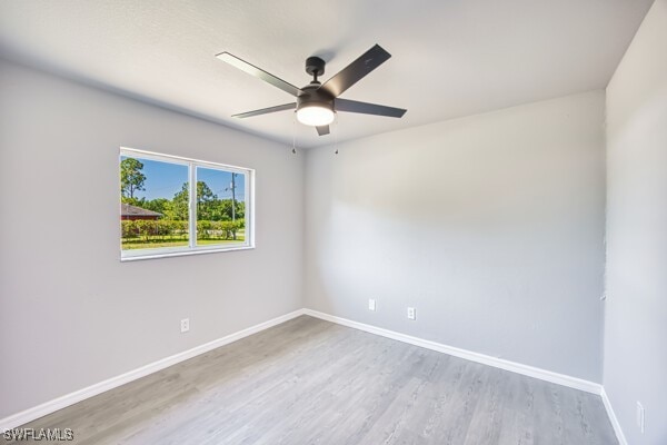 3815 Kittyhawk Dr, Fort Myers, FL 33905 - empty room with wood finished floors, a ceiling fan, and baseboards
