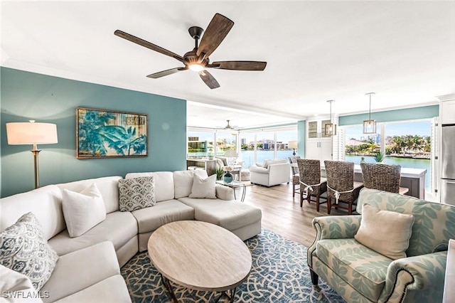 333 Harbour Dr Unit 201, Naples, FL 34103 - living room with a ceiling fan, wood finished floors, ornamental molding, and a water view
