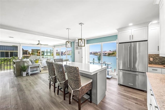 333 Harbour Dr Unit 201, Naples, FL 34103 - kitchen featuring high quality fridge, light countertops, light wood finished floors, a breakfast bar area, and recessed lighting