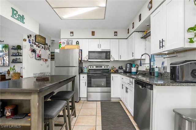 13031 9th St, Fort Myers, FL 33905 - kitchen featuring appliances with stainless steel finishes, a sink, white cabinetry, and light tile patterned flooring