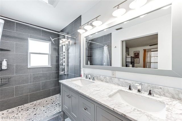 626 103rd Ave N, Naples, FL 34108 - bathroom featuring a tile shower and double vanity