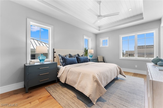 217 13th St S, Naples, FL 34102 - bedroom with a tray ceiling, light wood-style flooring, wood ceiling, baseboards, and ceiling fan