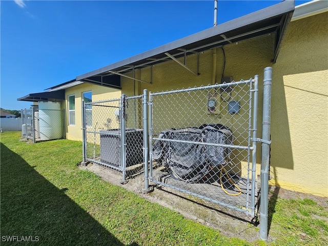 3903 1st St SW, Lehigh Acres, FL 33976 - view of side of home with stucco siding, a gate, and central air condition unit