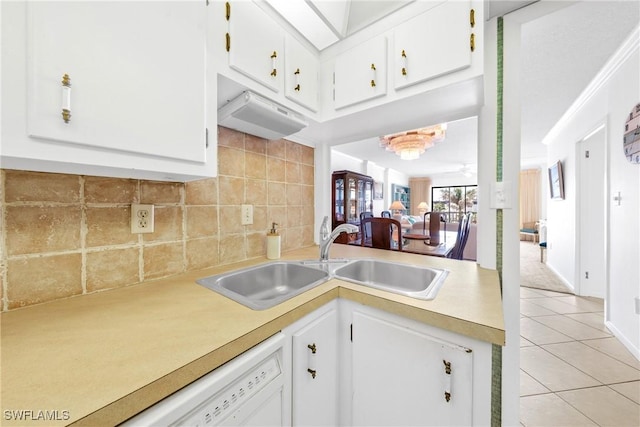 1977 Gulf Shore Blvd N Unit 302, Naples, FL 34102 - kitchen featuring a sink, light countertops, light tile patterned floors, backsplash, and white cabinetry