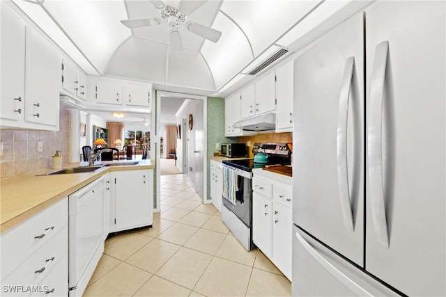 1977 Gulf Shore Blvd N Unit 302, Naples, FL 34102 - kitchen featuring white appliances, under cabinet range hood, light tile patterned flooring, white cabinets, and a ceiling fan
