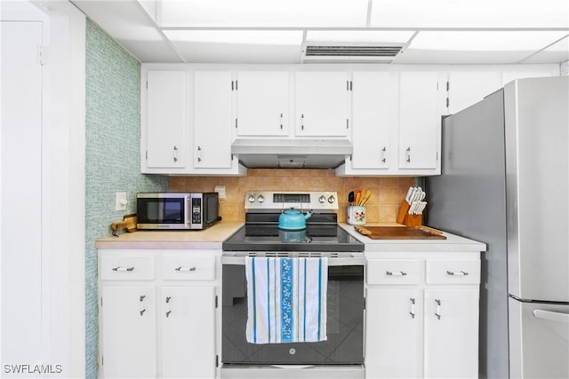 1977 Gulf Shore Blvd N Unit 302, Naples, FL 34102 - kitchen featuring stainless steel appliances, under cabinet range hood, light countertops, white cabinetry, and tasteful backsplash