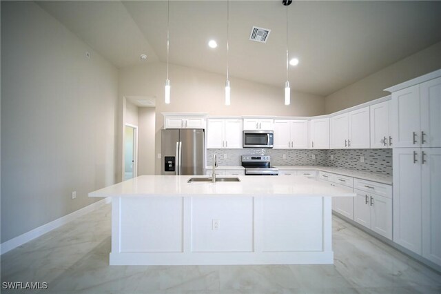 3711 6th St W, Lehigh Acres, FL 33971 - kitchen featuring appliances with stainless steel finishes, a sink, a kitchen island with sink, decorative backsplash, and light countertops