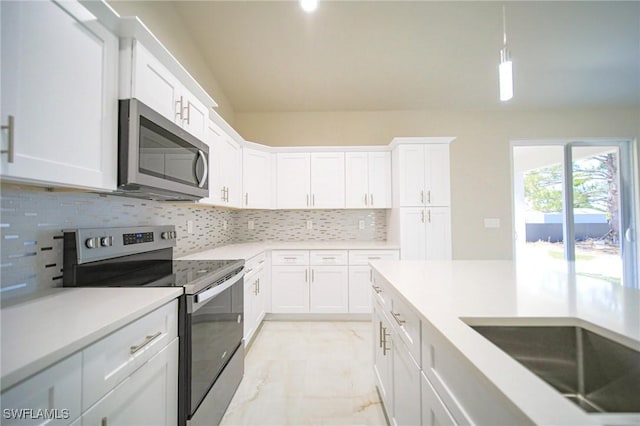 3711 6th St W, Lehigh Acres, FL 33971 - kitchen with stainless steel appliances, light marble finish floors, white cabinets, and backsplash