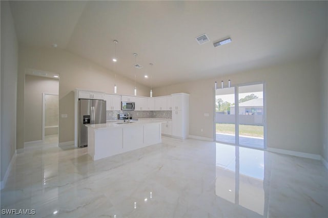 3711 6th St W, Lehigh Acres, FL 33971 - kitchen featuring appliances with stainless steel finishes, a center island with sink, backsplash, white cabinetry, and light countertops