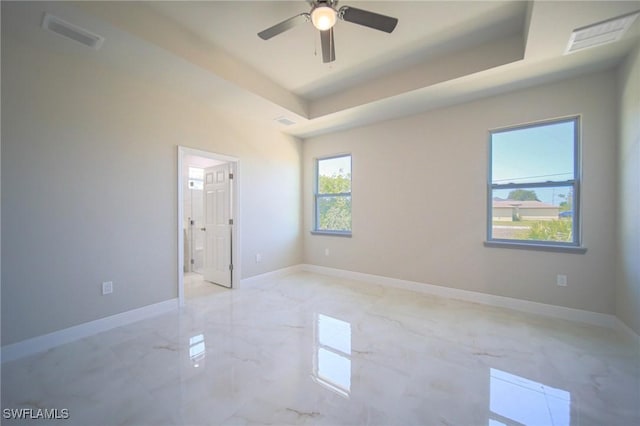 3711 6th St W, Lehigh Acres, FL 33971 - unfurnished bedroom featuring a raised ceiling, light marble finish flooring, and baseboards